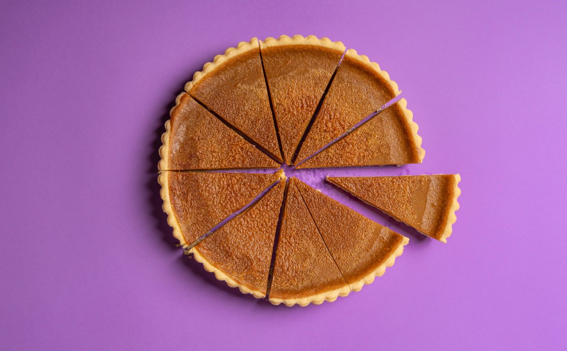 Sliced pumpkin pie and a separate piece. Top view. Traditional dessert